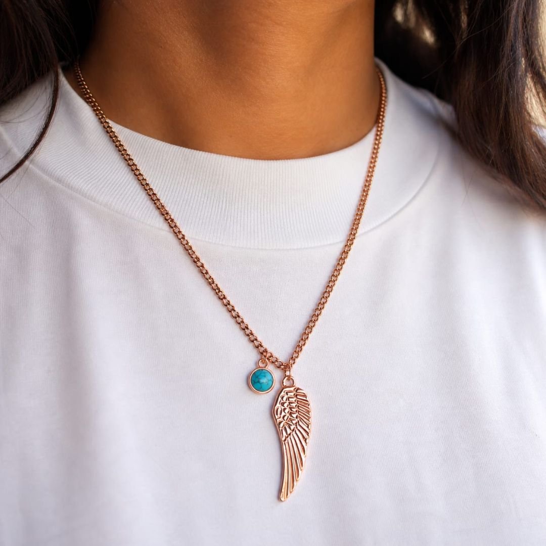Winged Whisper rose gold necklace with wing pendant and turquoise charm