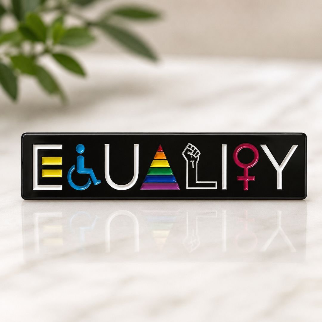 Equality enamel pin standing upright on marble surface with reflection pride lapel pin with plant