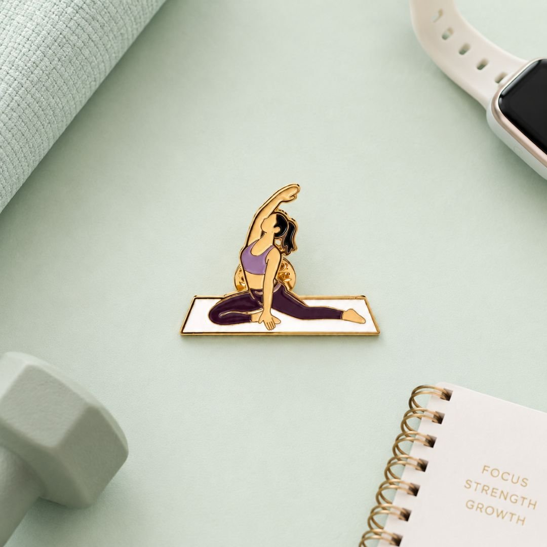 Yoga pose enamel pin wellness lapel pin green flat lay with Focus Strength Growth journal dumbbell and watch