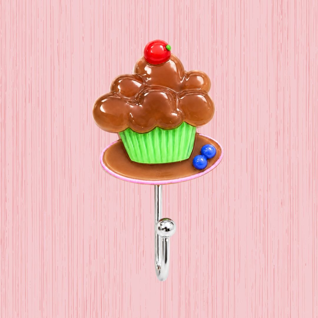 gooey chocolate cupcake self-adhesive wall hook with cherry top and green cup on pink background
