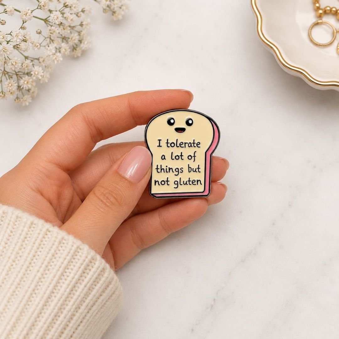 Gluten free enamel pin smiling bread slice kawaii funny lapel pin held in hand marble background