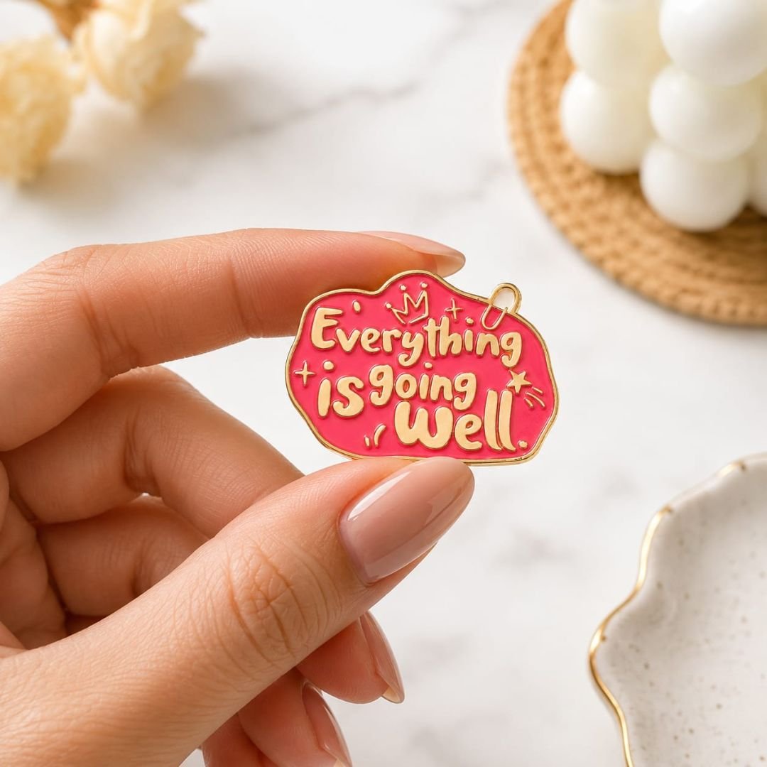 Everything Is Going Well hard enamel lapel pin with gold-tone lettering, gold-tone borders and bright pink enamel.