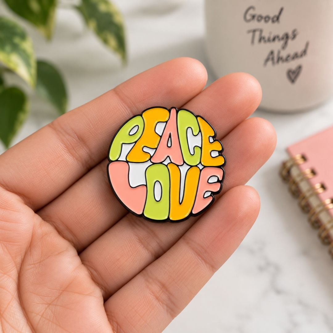 Peace Love colourful enamel pin held in hand